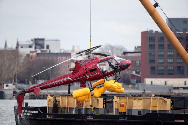 The tragic helicopter being taken from the water